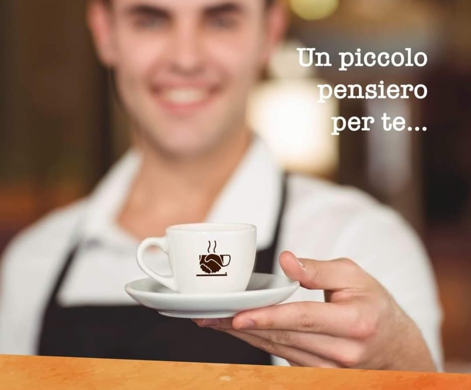 Barista di un bar partner porge una tazzina brandizzata Caffè Pagato