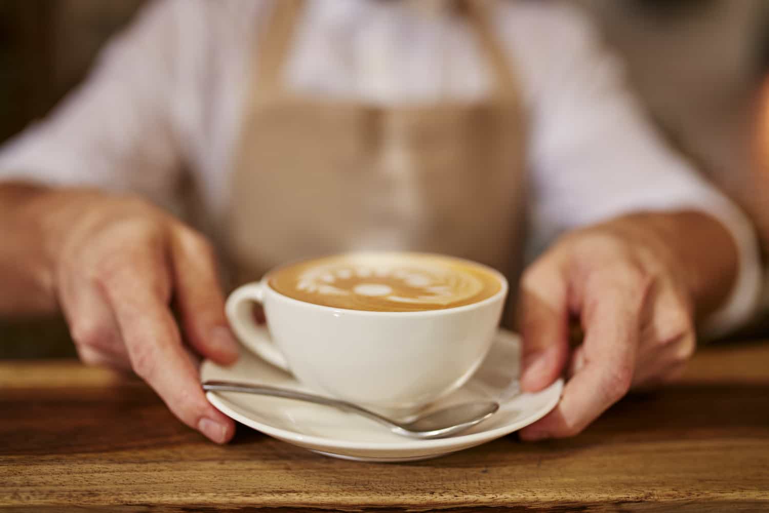 Barista serve un caffè in un bar partner di Caffè Pagato